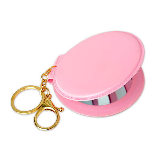 Pink round mirror with gold keychain on a white background