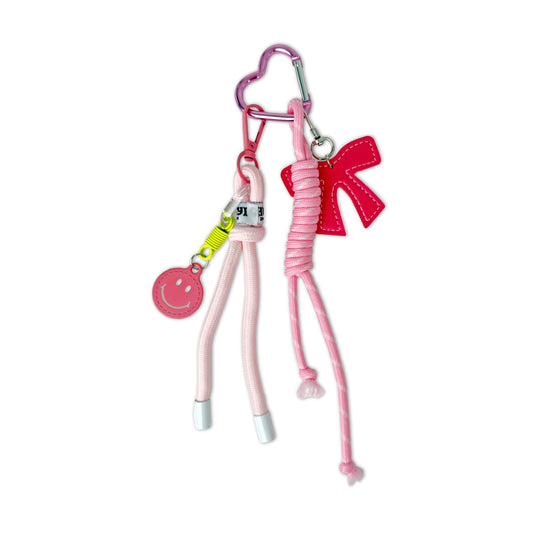 Pink keychain with a heart-shaped clip and bow on a white background