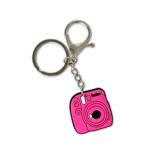 Pink camera-shaped keychain on a white background