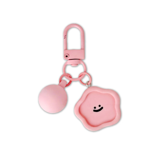 Pink keychain with a smiley face design on a white background